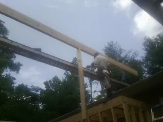 Carpenter setting a ridge beam over a new addition frame — Ice Dam Removal by Roofing Brothers in New Carlisle