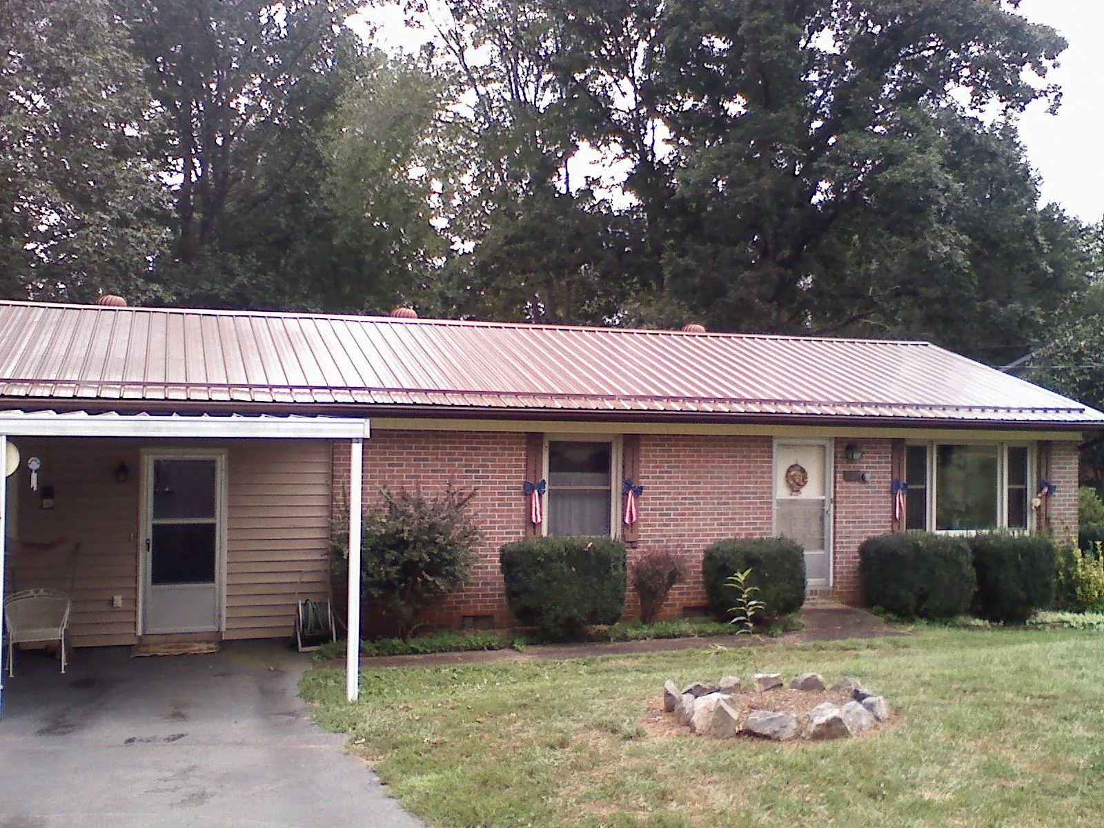 Bronze metal roof and carport on a brick ranch home — Roof Repair work by our crew in New Carlisle